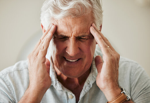 Senior man, suffering with headache pain from stress and painful head migraine. Elderly people at risk for mental health problems like anxiety and depression or loneliness from old age in retirement