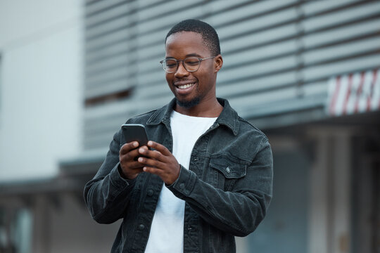 Black man, phone and social media in city reading text message or communication on social network app. African American person, chat conversation and happy on 5g mobile smartphone in Atlanta smile - Powered by Adobe