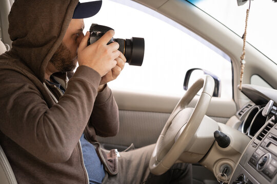 A male driver photographing with Slr camera from car