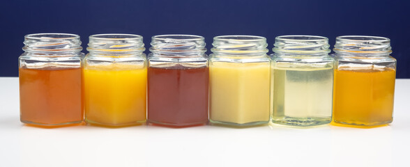 Hexagonal jars with different types and colors of fresh flower honey. vitamin food for health and life