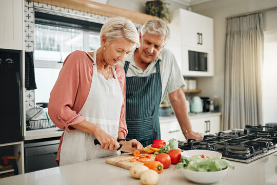 Senior couple, healthy food and cooking lunch together in Australia kitchen at home. Happy woman, hungry man and retirement people cut vegetables for nutrition diet, wellness and vegan dinner meal