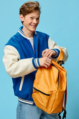 handsome nice guy joyfully unzips his orange backpack to get items out of there