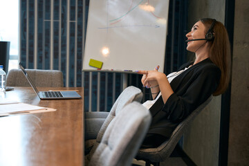 Smiling online shop worker talking to customer via Skype