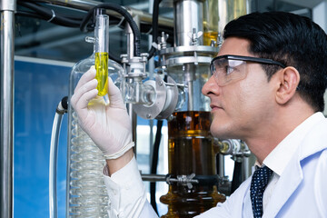 Selective focus at lab beaker, test tube while scientist study and examine with chemical or essential oil for medicine inside test laboratory. Chemical engineer work process with copy space for text.