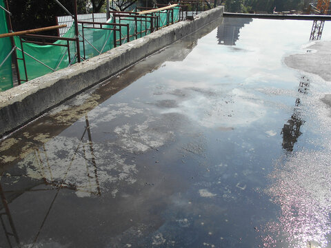 MELAKA, MALAYSIA -JULY 1, 2022: Waterproofing membrane applied by construction workers on top of the concrete slab. Waterproofing layer to prevent water from penetrating below the concrete slab. 
