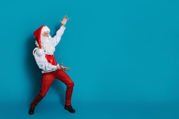 Fototapeta na wymiar Full size photo of cool santa claus who gesturing hands pointing to ad text. New Year advertisement