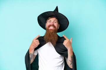 Young wizard in halloween isolated on blue background giving a thumbs up gesture