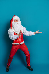 Fototapeta na wymiar Full size photo of santa claus who gesturing hands pointing to ad text. New Year advertisement 