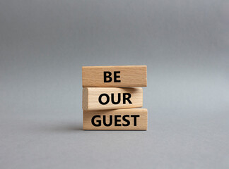 Be our guest symbol. Concept word Be our guest on wooden blocks. Beautiful grey background....