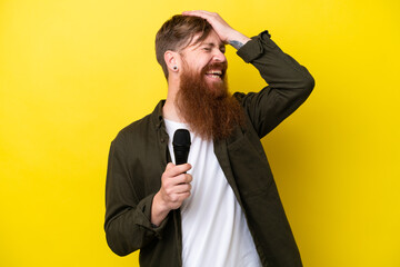 Naklejka premium Redhead man with beard picking up a microphone isolated on yellow background has realized something and intending the solution