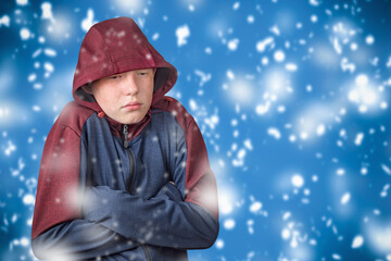 A teenager dressed in a hoodie is shivering in the cold. The concept of economic and energy crisis...