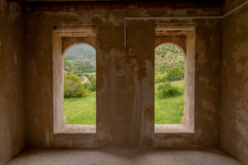 Big windows of historic stone mansion. Nature view from the window
