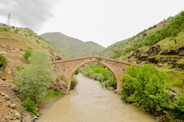 Fototapeta na wymiar Historic stone bridge. Old stone bridge in the mountains. natural landscape. 