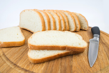 sliced bread and a knife on a white background. White bread slices