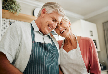 Senior couple, love and cooking while wearing an apron, laughing and happy bonding together in...