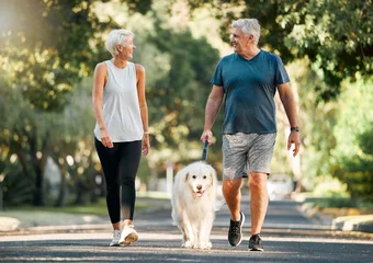 Tuinposter Retirement, fitness and walking with dog and couple in neighborhood park for relax, health and sports workout. Love, wellness and pet with old man and senior woman in outdoor morning walk together © Kay Abrahams/peopleimages.com