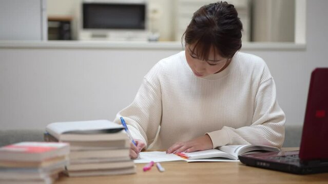 ノートパソコンを使って勉強する女性
