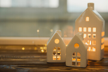 Autumn composition of candles and candlesticks miniature house on a wooden table.Christmas decor....