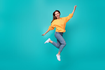 Fototapeta na wymiar Full length photo of young adorable pretty cute woman wear orange sweater jean jump carefree celebrate party isolated on aquamarine color background