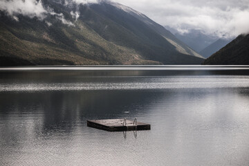 lonely wooden platform with metal ladder to facilitate swimming in the calm lake with rippled water...