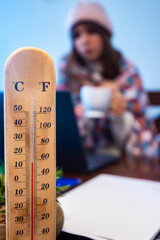woman freezes while working in office; cold at home; cold at work; gas crisis 2022; winter 2022; blackout; no heating; heating problems in europe; home office