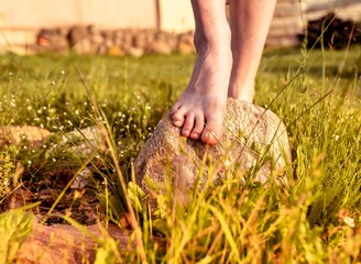 Girls feet on natural stone in nature. Women barefoot legs outdoors