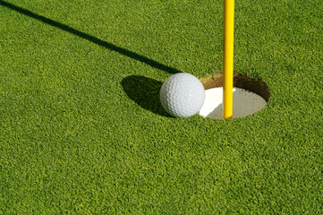 Close-up of Golf Course Green, Flag Pin and Ball.