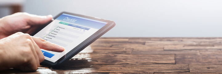 Businessperson Filling Checklist Form On Digital Tablet