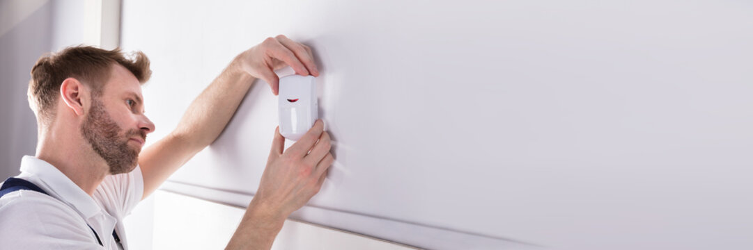 Electrician Installing Security System Door Sensor