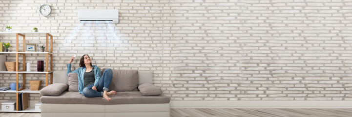 Woman Relaxing Under The Air Conditioner