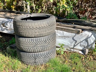 Rubber tires from a car on the grass. The problem of ecology and environmental pollution, processing of rubber waste from production and automotive industry