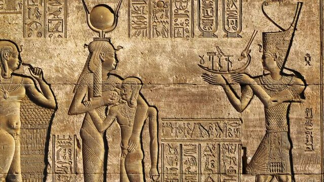 Hieroglyphic carvings on the exterior walls of an ancient egyptian temple, zoom out