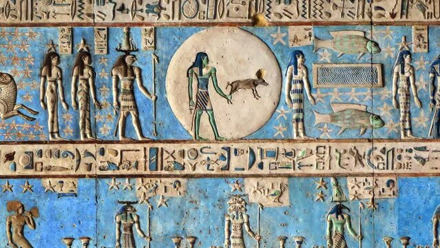 Hieroglyphic carvings and paintings on the interior walls of an ancient egyptian temple in Dendera, zoom out