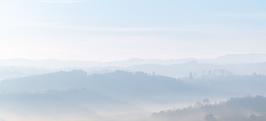 Hill layers in fog during morning in autumn, rural misty landscape