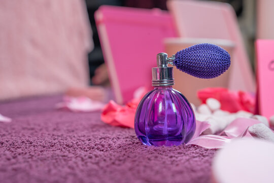 pompe &agrave; parfum r&eacute;tro violette dans un d&eacute;cor rose