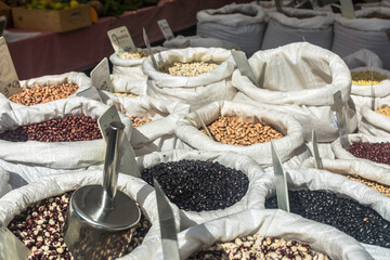 Variety of seeds and legumes for sale in a farmer market outdoor. sacks of mixed beans and grains. Healthy cuisine.