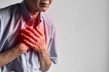 Asian man suffering from central chest pain. Chest pain can be caused by heart attack, myocardial...