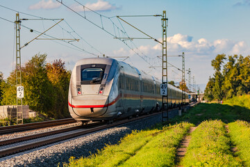 Eine Bahntrasse mit einem ICE in ländlichem Gebiet hilft bei der Mobiolitätswende im Personenverkehr, Deutschland