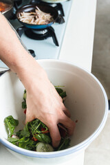 person chopping vegetables, to make a salad and getting food ready to cook. Prepare vegetables to make a healthy meal. Hand mixing a salad in a bowl. Latin American cuisine