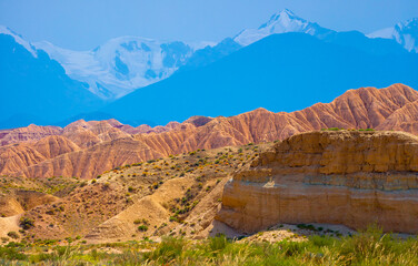Natural unusual landscape of red rocks against the backdrop of blue mountains. The extraordinary beauty of nature is similar to the Martian landscape. Amazingly beautiful landscape.