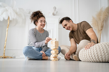 young couple woman and man play jenga game at home