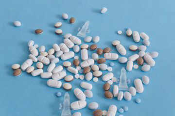Pastillas y gotas esparcidas sobre fondo azul