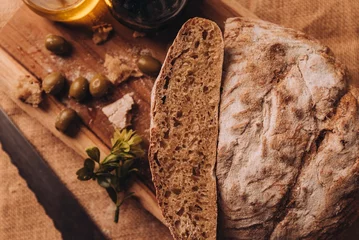 Foto op Canvas Close-up shot of cut bread on a wooden board © Nacho Ramirez/Wirestock Creators