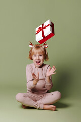 Girl with a Christmas present on a green background.