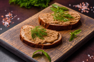 Homemade meat snack liver pate with toast on a dark concrete background
