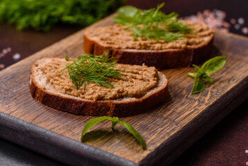 Homemade meat snack liver pate with toast on a dark concrete background