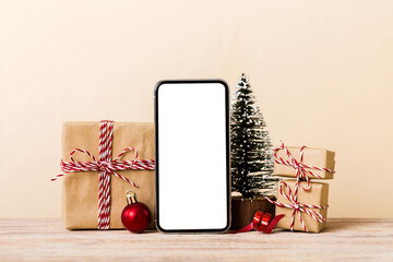 Digital phone mock up with rustic Christmas decorations for app presentation with empty space for you design. Christmas online shopping concept. Tablet with copy space on colored background