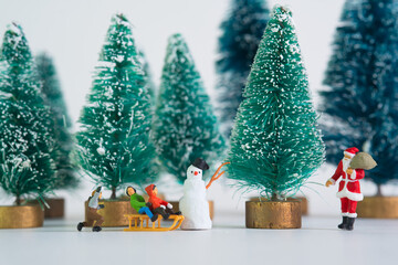 Children stand in a row in front of Santa Claus, fir trees in the background
