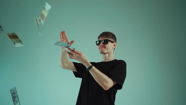 young happy attractive rich man throwing money, dollar and euro banknote