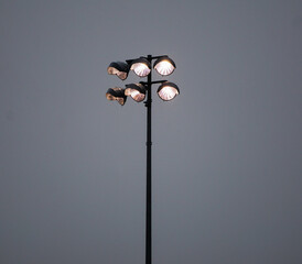 Lamp post in a stadium during a raining night.